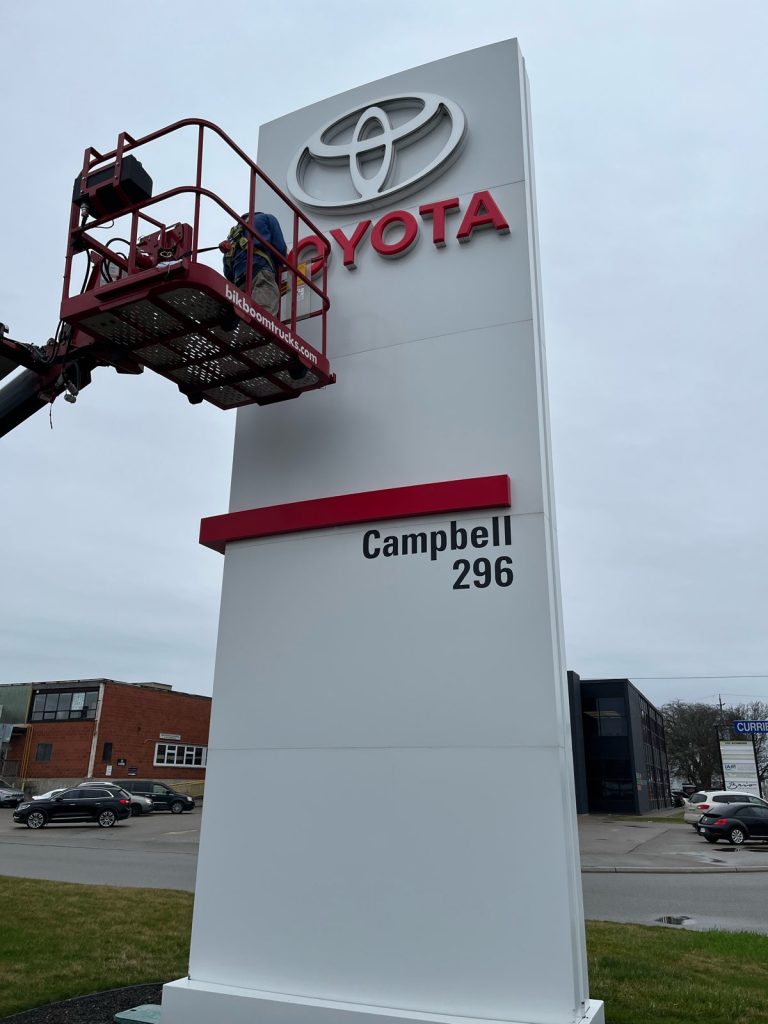 The Toyota Dealership sign being service by YESCO with a bucket ladder